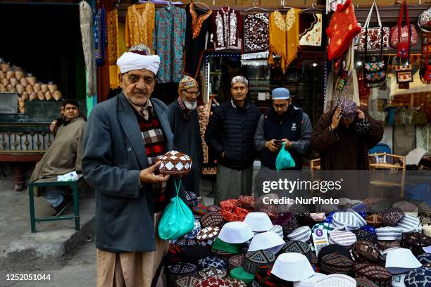 Kashmiri Muslims purchase prayer skull caps from a market ahead of Muslim festival Eid-ul-Fitr in Srinagar Jammu and Kashmir India on 21 April 2023