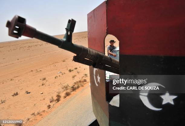 Rebel is pictured in convoy behind a heavy artlilerry weapon mounted on a truck, after patrolling the village of Wadi Mardum, 30 km from Bani Walid,...