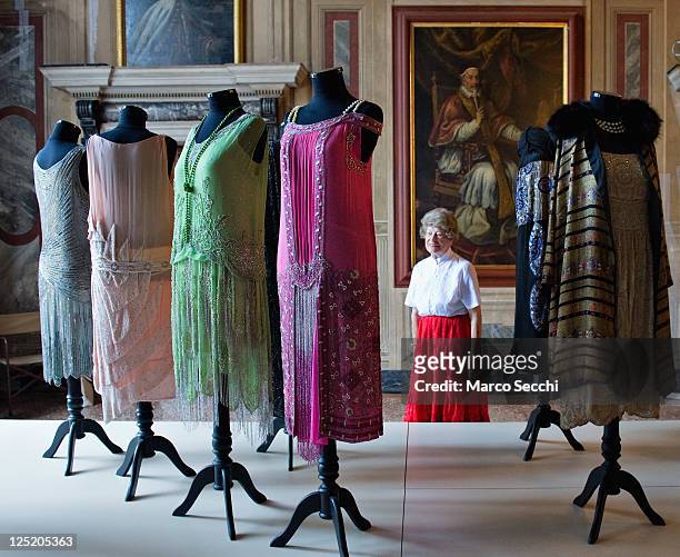 Woman admires some dresses belonging to the collection of Alexander Vassiliev during the press preview of "Elegance in Exhile" at Palazzo Mocenigo on...