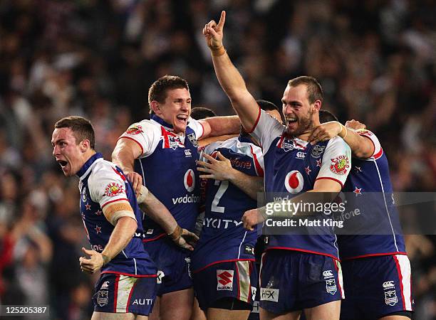 James Maloney, Jacob Lillyman and Simon Mannering of the Warriors celebrate victory at fulltime during the NRL first semi final match between the...