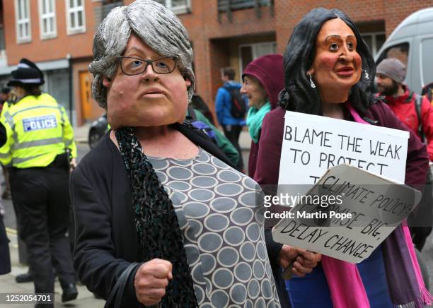 Rebels wearing headpieces of Environment Secretary, Therese Coffey and Home Secretary, Suella Braverman as they come together in the protest march on...
