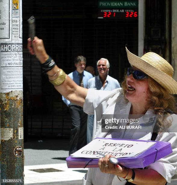 Saver hits a steal beam that holds up a traffic light in the financial district of Buenos Aires, Argentina 15 January, 2003. Una ahorrista golpea un...