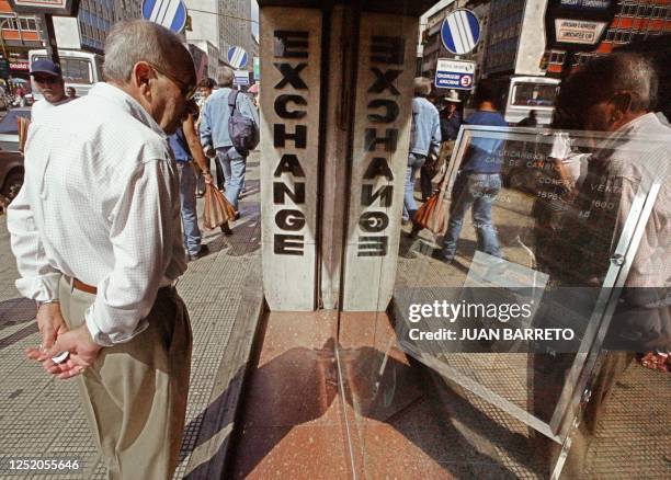 An unidentified man stands outside a closed money exchange office, 06 February 2003, in Caracas. Venezuelan President Hugo Chavez announced drastic...