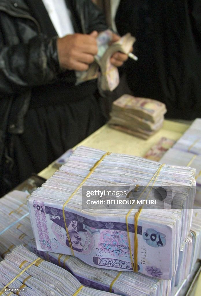 Iraq Money Stack An Iraqi Kurdish money changer counts old Iraqi Dinars as more recent ...