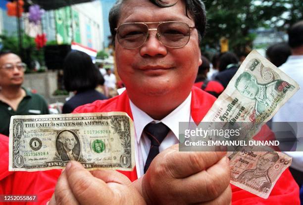 Bank official displays his desire to have the Thai unit go back to an exchange rate of 30 baht to the US dollar 11 January during a march down a...