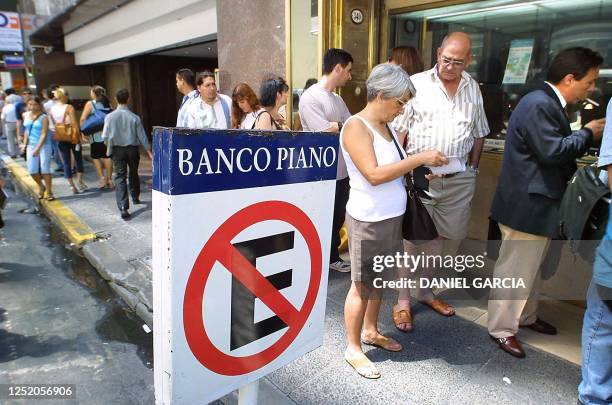 Hundreds of argentinians wait in line at the exchange house in Buenos Aires where the dollar's exchange rate is displayed 25 January 2002. Several...