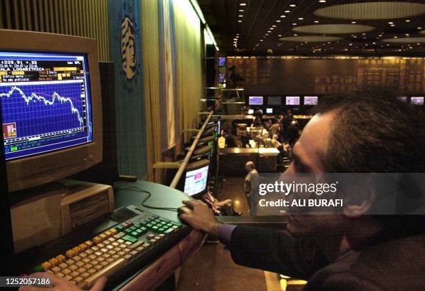 An trader is seen reading a graph relating to the Argentine stock exchange 31 October in Buenos Aires, Argentina. Un operador de la Bolsa de Valores...