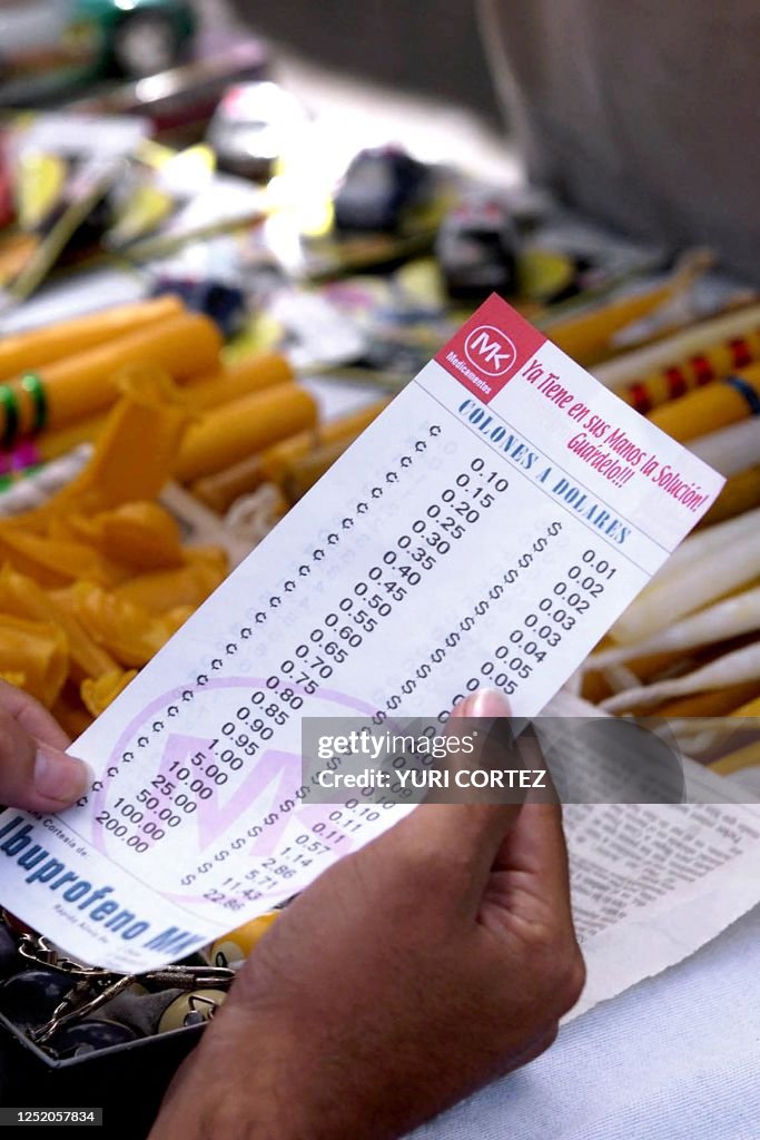 A vendor looks at a conversion chart 28 December 2000 from colones to