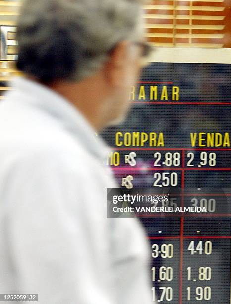 Civilian walks by a board showing the current exchange rates in Rio de Janeiro, Brazil 20 August 2002. Un ciudadano observa la pizarra de cotización...