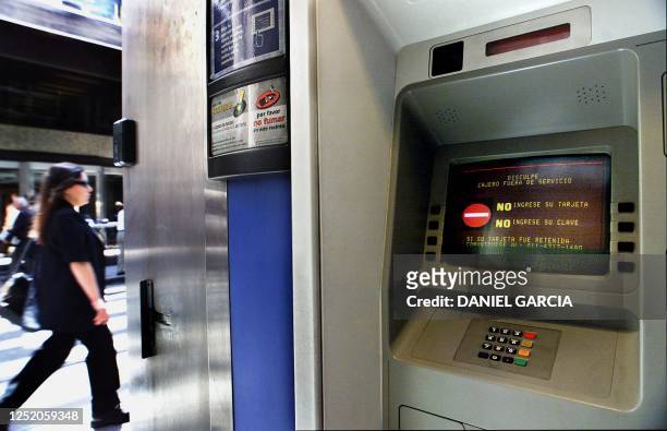 Woman walks in front of a closed ATM in Buenos Aires, 10 December 2001 during the implementation of government economic measures. Una mujer pasa...