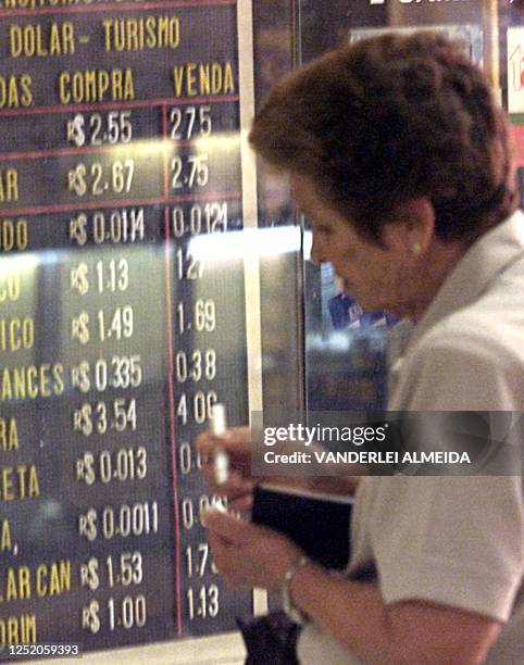 Woman is seein writing down the exchange rates in Rio de Janeiro, Brazil 04 October 2001. Una mujer anota la cotizacion del dolar ante la moneda...