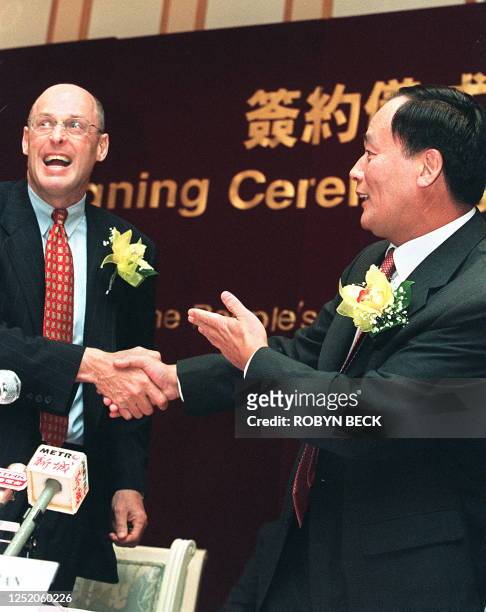 Goldman Sachs Co-Chairman and CEO Henry Paulson celebrates with Wang Qishan , executive vice governor of southern China's Guangdong province the...
