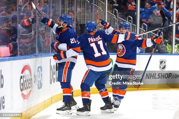Kyle Palmieri of the New York Islanders is congratulated by Zach Parise and Scott Mayfield after scoring a goal against the Carolina Hurricanes...