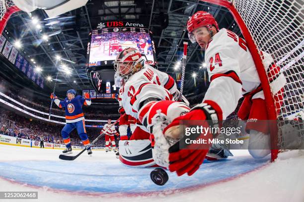 Seth Jarvis of the Carolina Hurricanes prevents a shot by Hudson Fasching of the New York Islanders from going into the goal as Antti Raanta...