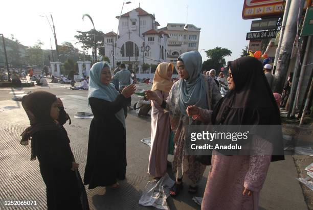 Indonesian Muslim women exchange greetings at Matraman Raya Streets after performing Eid al-Fitr prayer to mark the end of the Islamic holy month of...