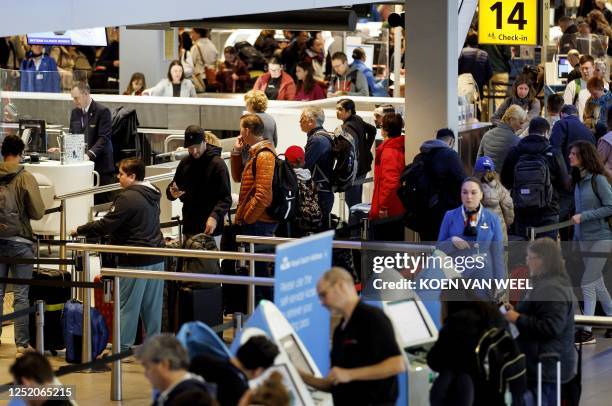 Travelers wait in line to check in at Schiphol Airport, near Amsterdam, on April 22, 2023. / Netherlands OUT