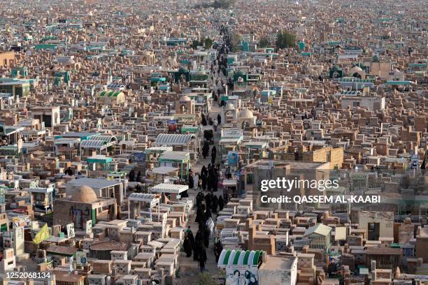 Group of Shiite women walk through the Wadi-al-Salam cemetery in Iraq's holy shrine city of Najaf on April 22 to visit the tombs of deceased...