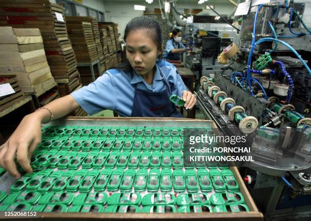 Photo prise le 18 décembre 2003 à Phatumthanee, au nord de Bangkok, d'une employée thaïlandaise travaillant sur une chaîne d'assemblage de l'usine...