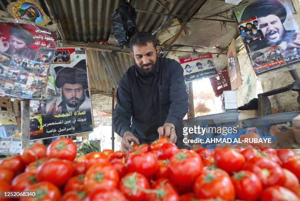 Man sells fruits at his stall decorated with posters of radical Shiite Muslim cleric Moqtada Sadr in the poor neighborhood of Sadr City 10 April...