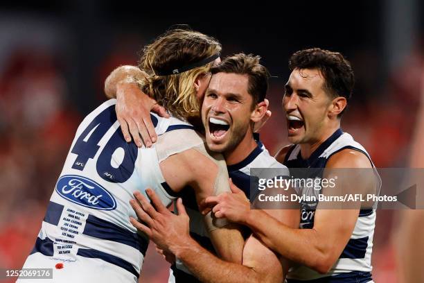 Tom Hawkins of the Cats celebrates a goal with teammates Mark Blicavs and Sam Simpson during the 2023 AFL Round 06 match between the Geelong Cats and...