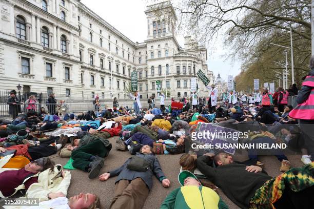 Protesters take part a mass 'die-in' outside of the Treasury Offices during a demonstration by the climate change protest group Extinction Rebellion,...