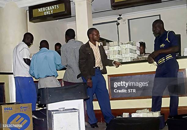 Depositors take turns to hand in boxfuls of the old bearer cheques at a bank in central Harare 21 August 2006 as Zimbabwe's central bank phased out...