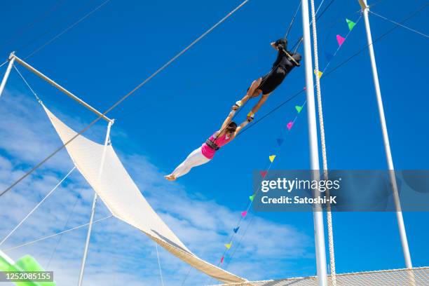 空をつなぐトラピーズアーティスト - trapeze ストックフォトと画像