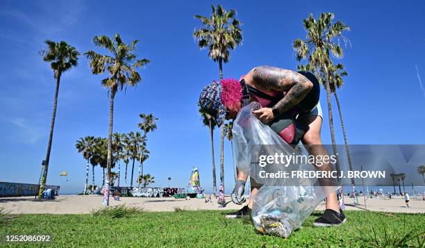 Joey Cacace helps clean up the trash at Venice Beach for Earth Day on April 22 in Los Angeles, California. - Beach and river cleanups are being held...