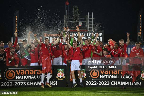 Wrexham's English midfielder Luke Young and Wrexham's English defender Ben Tozer lift the National League trophy as players and staff celebrate on...