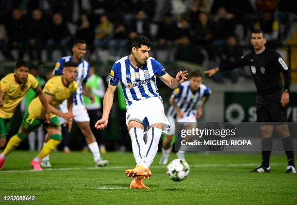 Porto's Iranian forward Mehdi Taremi scores a penalty shot during the Portuguese league football match between FC Pacos de Ferreira and FC Porto at...