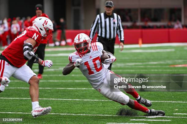 Running back Anthony Grant of Nebraska Cornhuskers slips avoiding the tackle of lineman Brodie Tagaloa of Nebraska Cornhuskers at Memorial Stadium on...