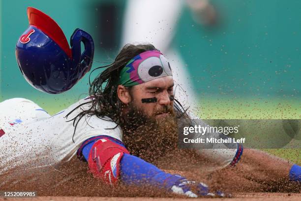 Brandon Marsh of the Philadelphia Phillies slides safely into third base on his triple in the bottom of the seventh inning against the Colorado...