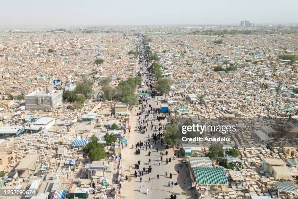 An aerial view of Muslims visiting the graves of their late relatives and pray for them during Eid al-Fitr at Wadi al-Salaam Cemetery in Najaf, Iraq...
