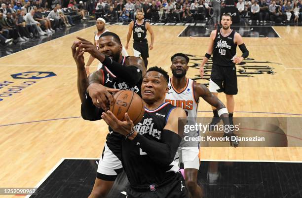 Russell Westbrook of the Los Angeles Clippers pulls down a rebound with Marcus Morris Sr. #8 defending against Deandre Ayton of the Phoenix Suns...