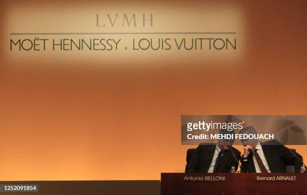 Head of French luxury goods maker LVMH Bernard Arnault speaks with the group delegate general director Antonio Belloni during a press conference to...