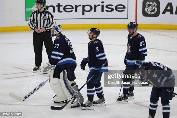 Connor Hellebuyck, Dylan DeMelo, Pierre-Luc Dubois and Dylan Samberg of the Winnipeg Jets skate off after losing to the Vegas Golden Knights in the...