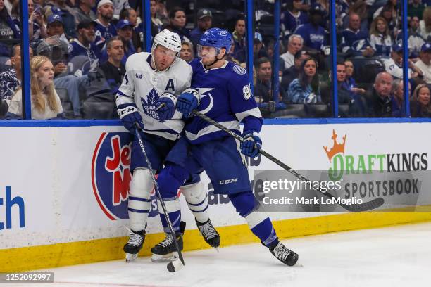 Tanner Jeannot of the Tampa Bay Lightning checks Morgan Rielly of the Toronto Maple Leafs during the second period in Game Three of the First Round...