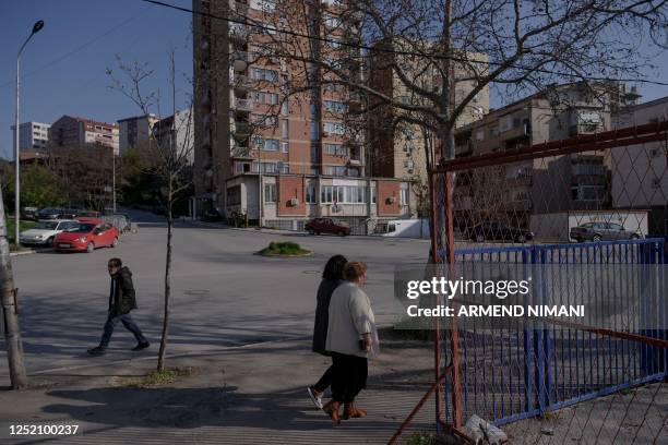 People walk near a polling station in the north of Mitrovica, predominantly populated by the ethnic Serb minority amid the municipal elections in the...