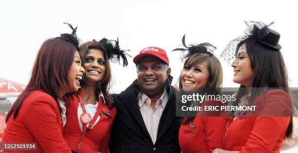 AirAsia founder and chief executive officer Tony Fernandes poses with stewardesses upon the landing of the first flight Kuala-Lumpur-Paris by a...