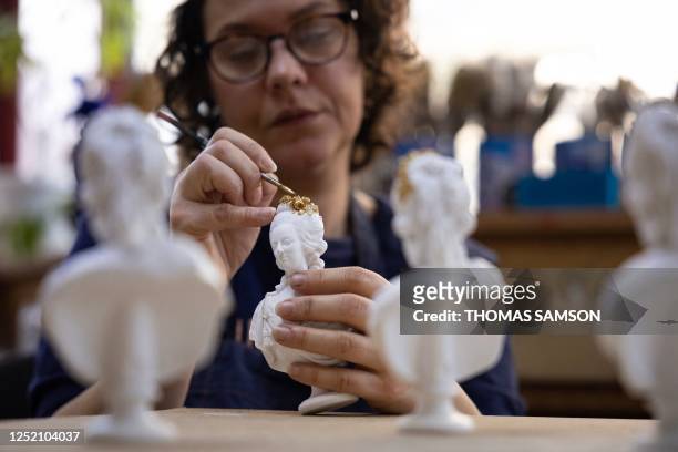 Patina artist Julie Guillamier applies metallic paint on a resin casting bust of Marie-Antoinette, at the Cast workshops of the Ateliers d'Art of the...