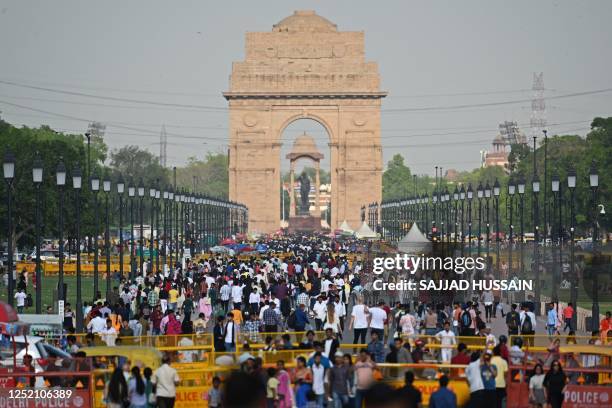 People crowd as they visit the India Gate in New Delhi on April 23, 2023. - India is set to overtake China as the world's most populous country by...