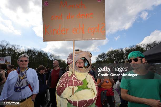 Participant with a sea turtle costume holds a banner as activists of the "Last Generation" climate action movement protest at the Brandenburg Gate...