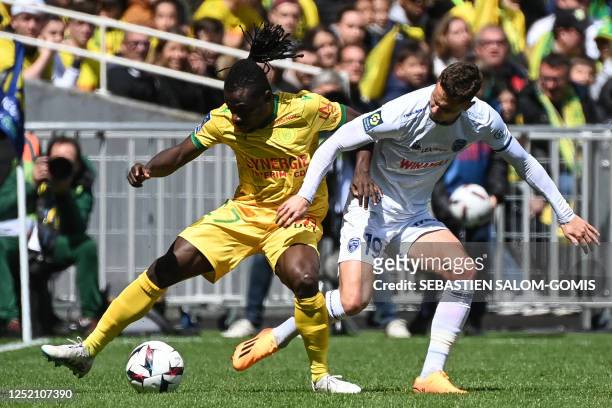 Nantes' Nigerian midfielder Moses Simon fights for the ball with Troyes' Danish defender Andreas Bruus during the French L1 football match between FC...