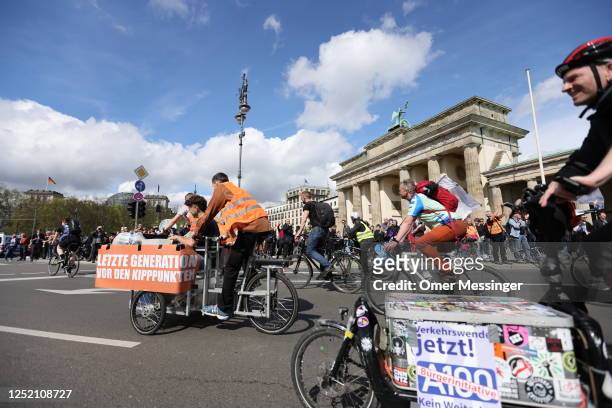 Activists of the "Last Generation" climate action movement, some on bicycles, protest at the Brandenburg Gate under the motto: "Stop the climate...