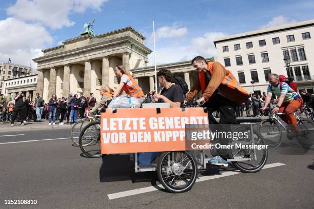 Activists of the "Last Generation" climate action movement, some on bicycles, protest at the Brandenburg Gate under the motto: "Stop the climate...