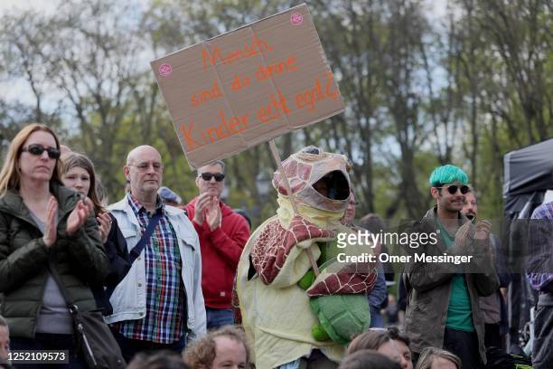 Participant with a sea turtle costume stands among other activists of the "Last Generation" , during a climate action movement protest at the...