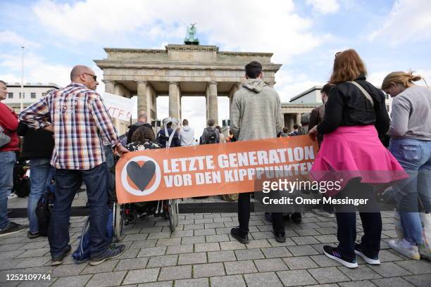 Activists of the "Last Generation" climate action movement protest at the Brandenburg Gate under the motto: "Stop the climate collapse. Secure basic...