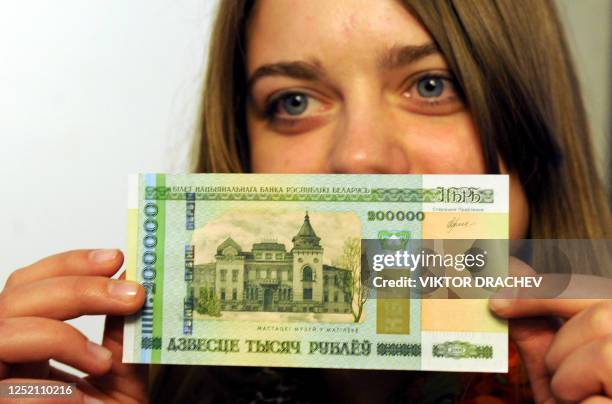 An official of Belarusian National Bank presents a new 200,000 ruble note in the bank headquarters in Minsk, on March 12, 2012. Belarus, gripped by...
