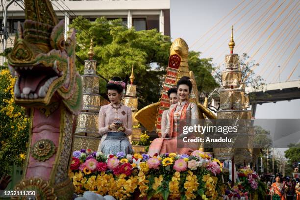 People wearing traditional clothing are seen on a float during the parade, with Bhumibol 2 Bridge in the background in Samut Prakan, Thailand on...