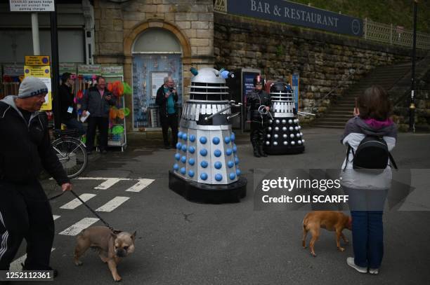 Members of the public walk past cosplayers dressed as Daleks, from the Doctor Who series, which are attending Sci Fi Scarborough at The Spa Complex...